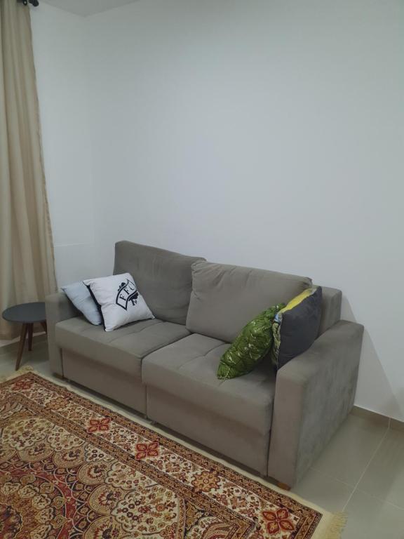 a couch with two pillows on it in a living room at De lucca home Studio in Florianópolis