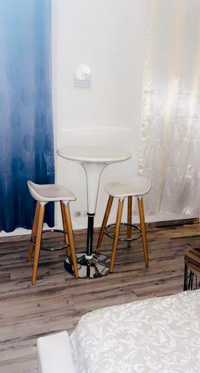 a table and two stools in a room with a bed at Owen in Montargis