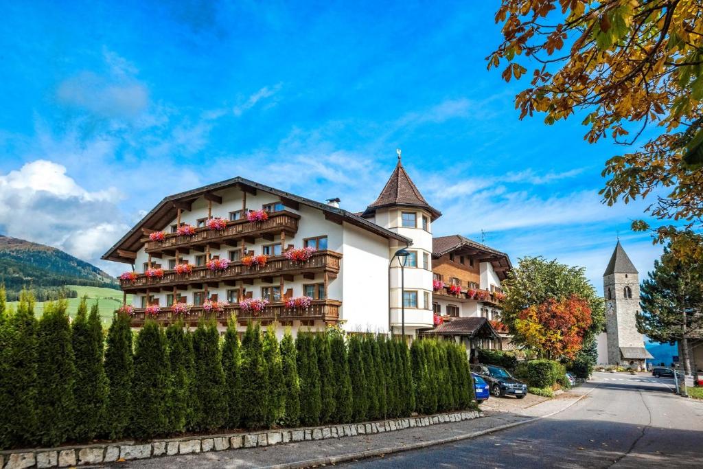 a building with flowers on the balconies on a street at Sporthotel Fichtenhof in Maranza