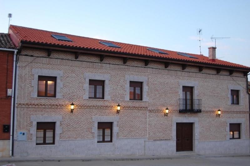 un gran edificio de ladrillo con techo rojo en La Casona de Doña Petra, en Villarmentero de Campos