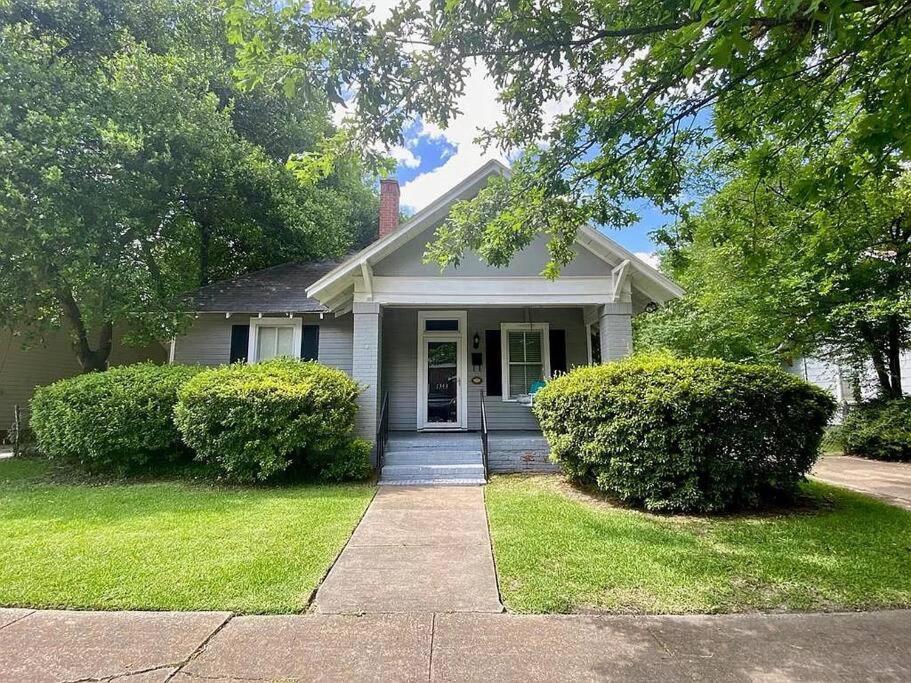 a white house with bushes in front of it at Charming and cozy home by a Historic District in Columbus