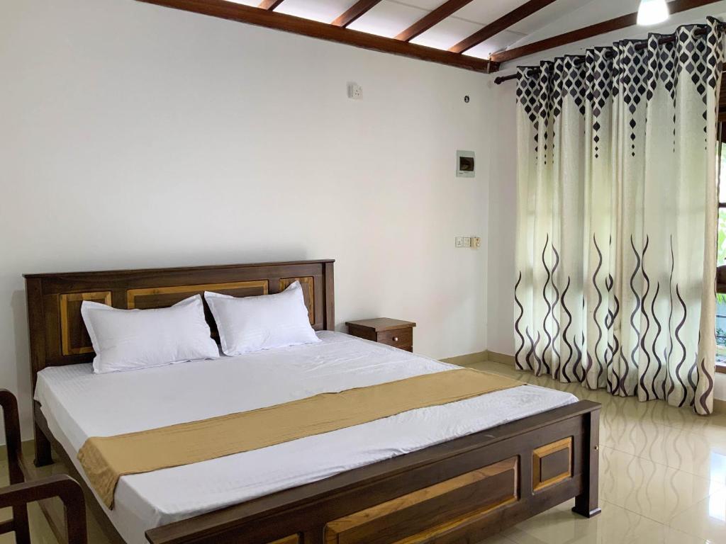 a bedroom with a bed and a window at Green Lodge in Weligama