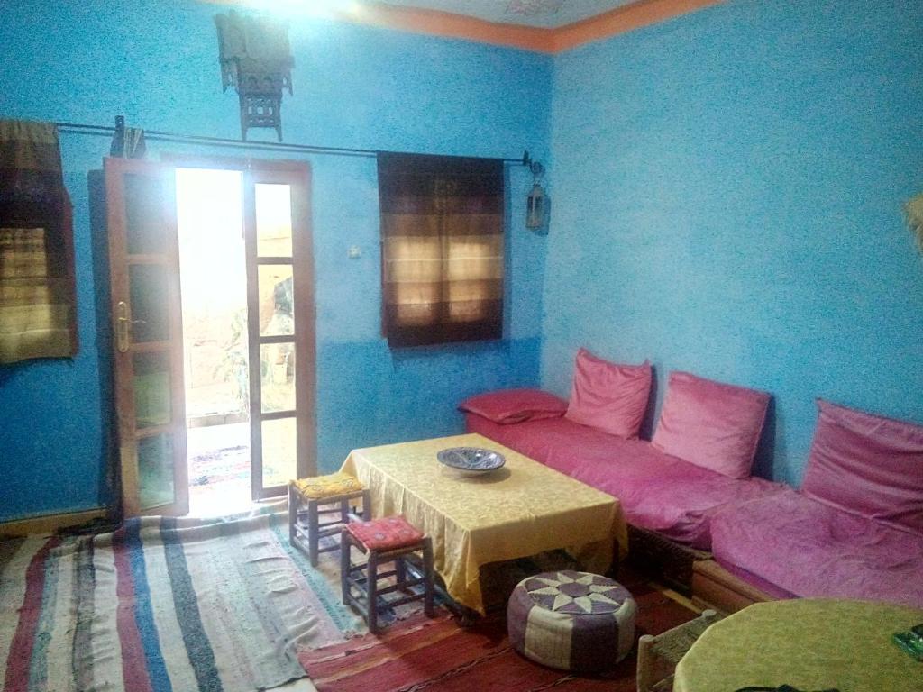 ein Wohnzimmer mit einem Sofa und einem Tisch in der Unterkunft Moha House in Merzouga