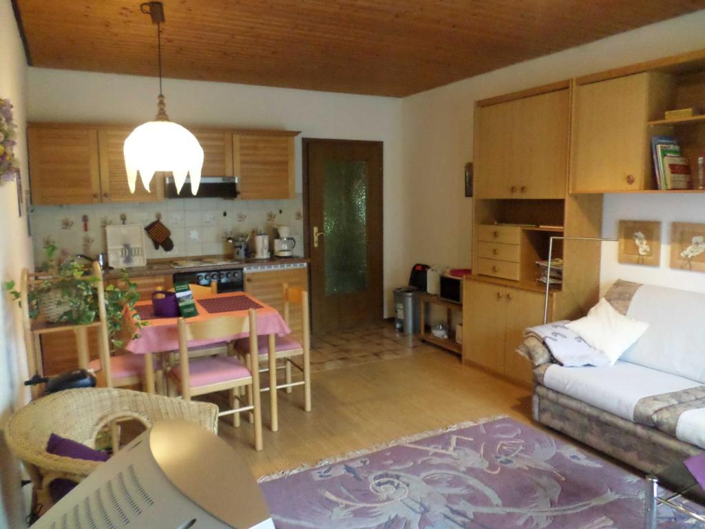 sala de estar y cocina con sofá y mesa en Ferienwohnung Kraemer en Mossautal