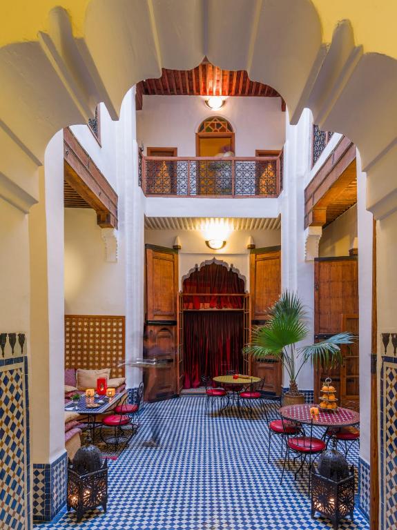 a lobby with tables and chairs and a balcony at Riyad Al Atik in Fez