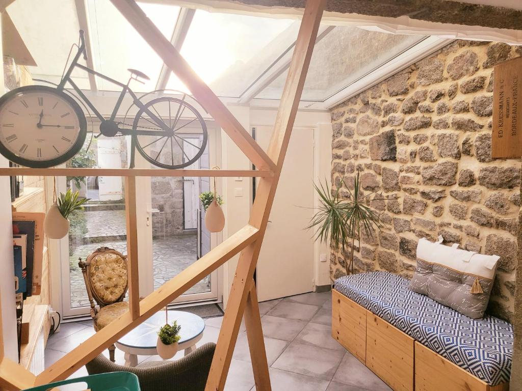 Habitación con pared de piedra y reloj en la pared en L'Héméra: Maison au coeur de Barfleur en Barfleur