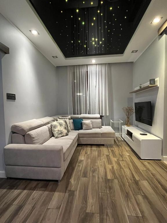 a living room with a couch and a television at Copernicus Dream Apartment Toruń Stare Miasto in Toruń