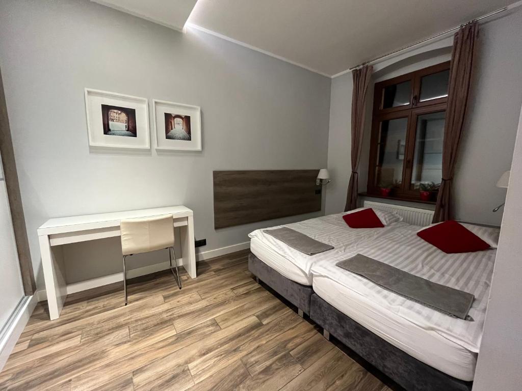 a bedroom with a bed and a desk in it at Copernicus Dream Apartment Toruń Stare Miasto in Toruń