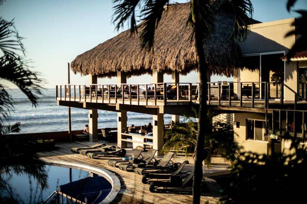 a resort with lounge chairs and a pier and the ocean at Casa de Mar Hotel And Villas in El Sunzal