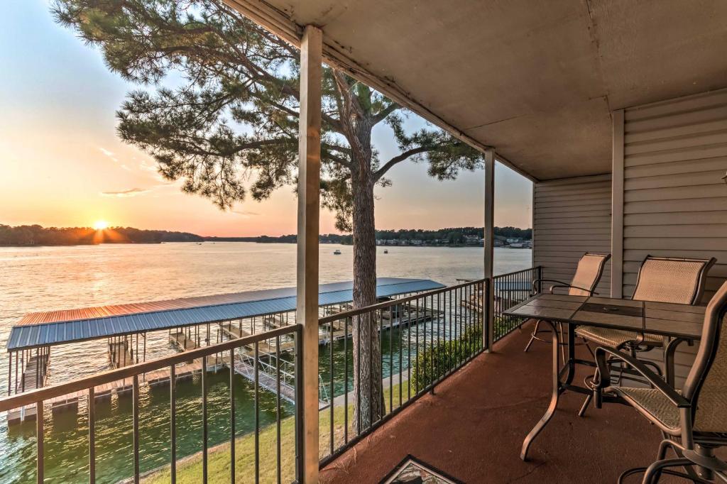 a balcony with a table and chairs and a view of the water at Sunset-View Resort Condo on Lake Hamilton! in Hot Springs