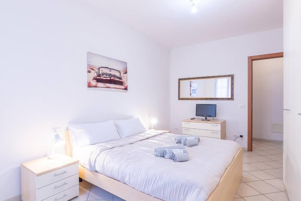 a white bedroom with a large bed and a television at [Esclusivo Loano centro] mare a 50 mt + Wi-Fi in Loano
