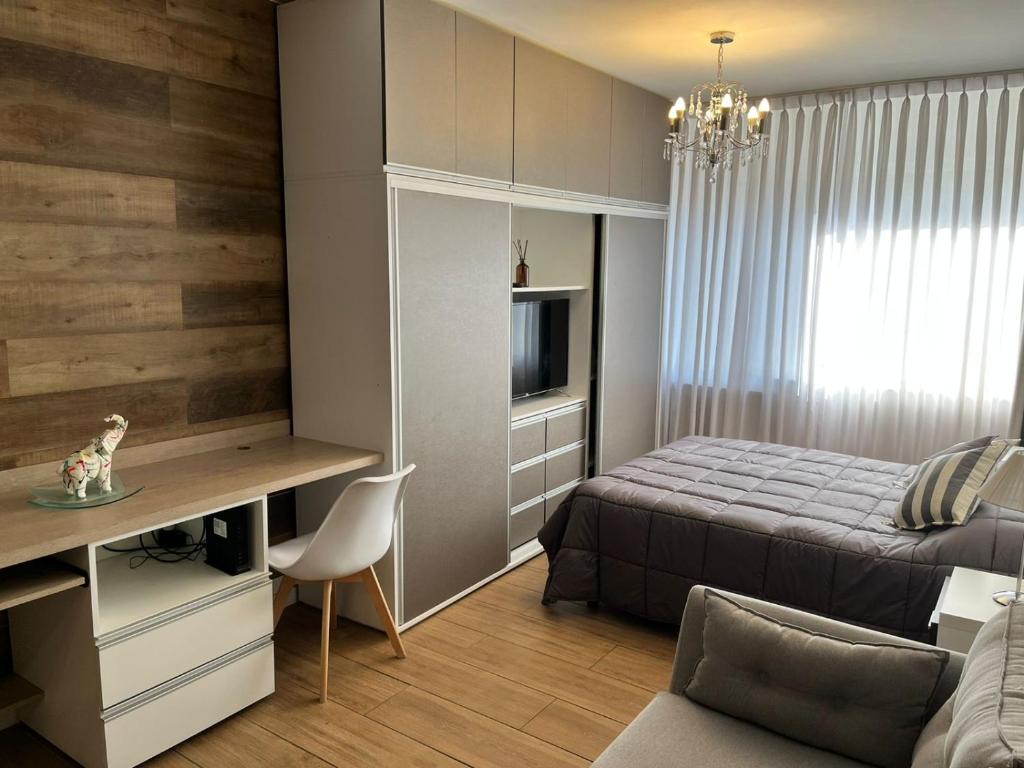 1 dormitorio con 1 cama y escritorio con TV en Apart. Av. Corrientes en Buenos Aires