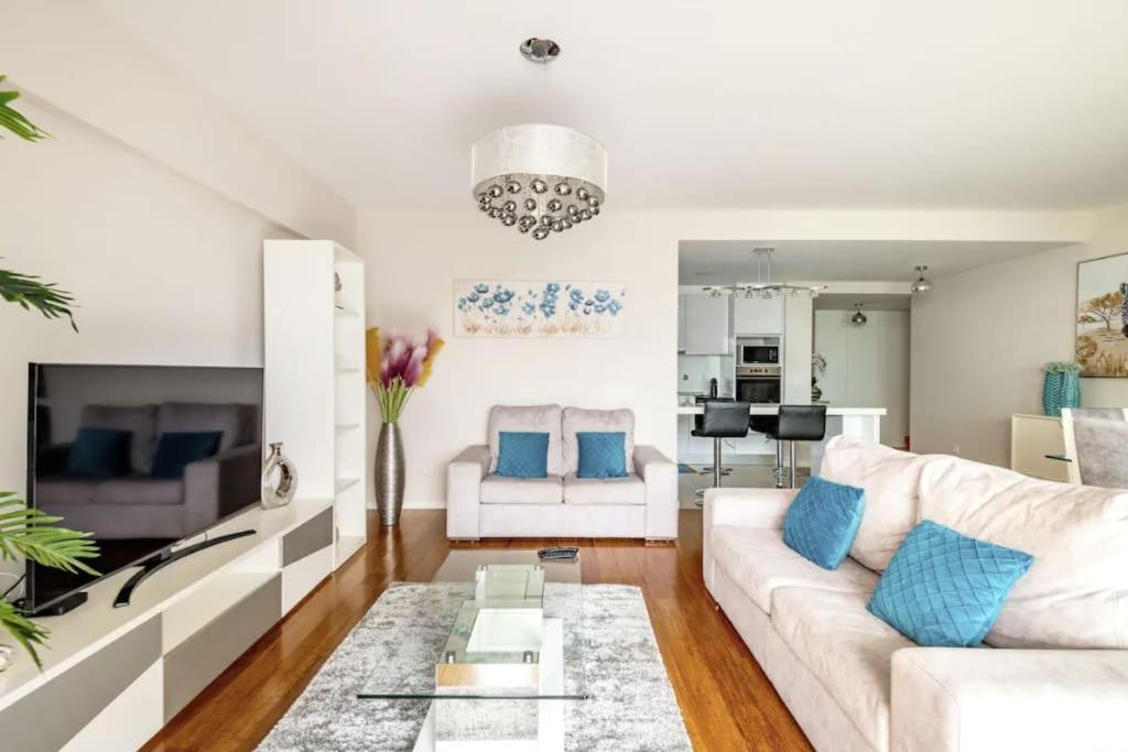 sala de estar con sofá blanco y almohadas azules en Luxury poolside view apartment, en Funchal
