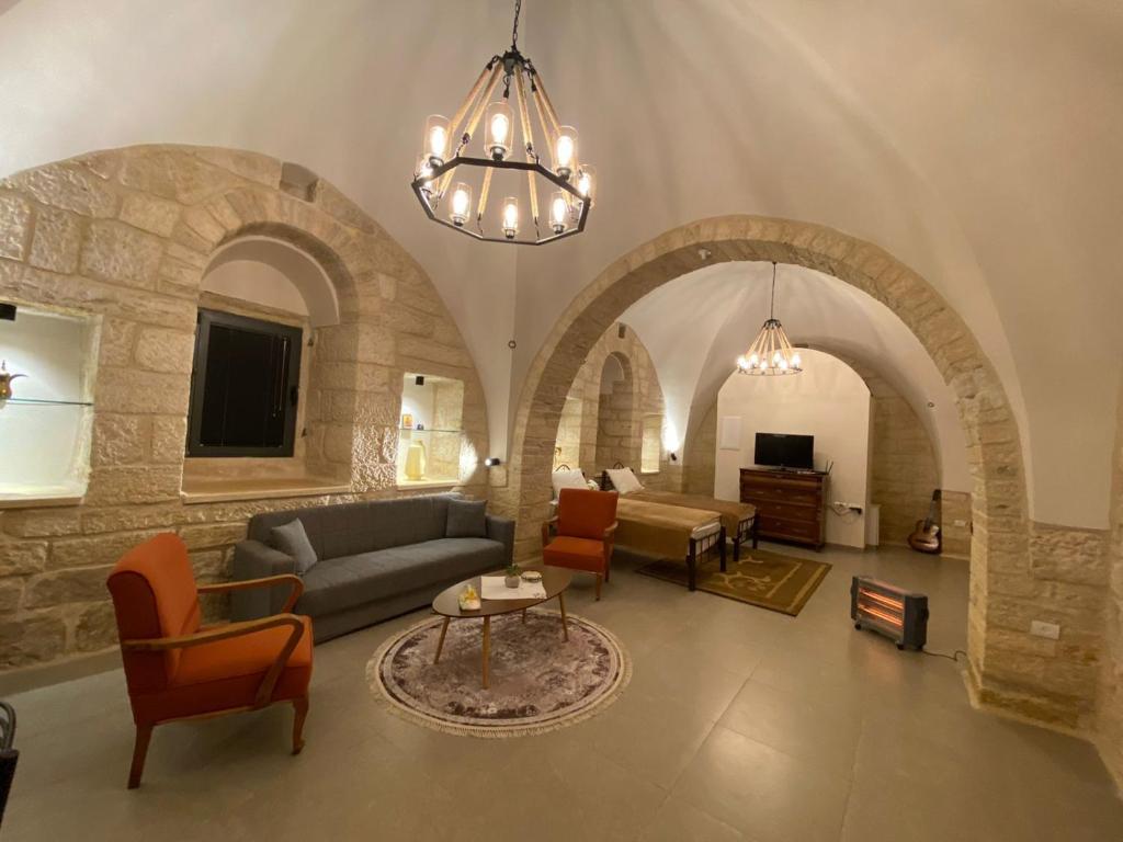 Star Street Studio in Bethlehem في بيت لحم: غرفة معيشة مع مقوس وأريكة وكراسي