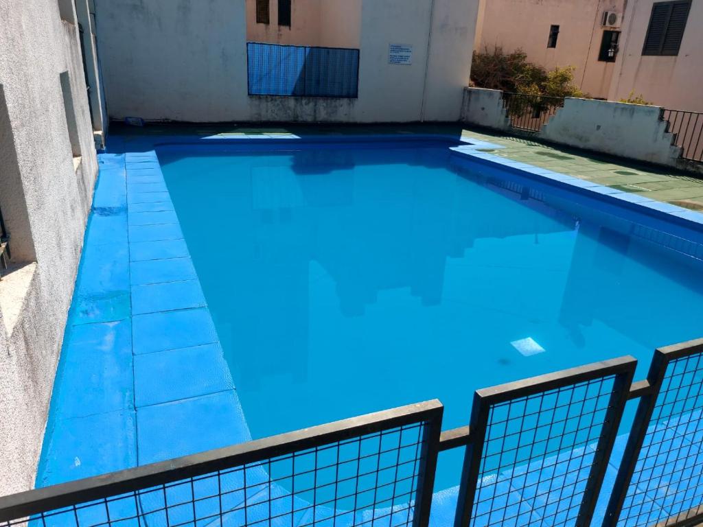 una piscina de agua azul en un edificio en Castillo Del Lago - Carlos Paz - D07 en Villa Carlos Paz