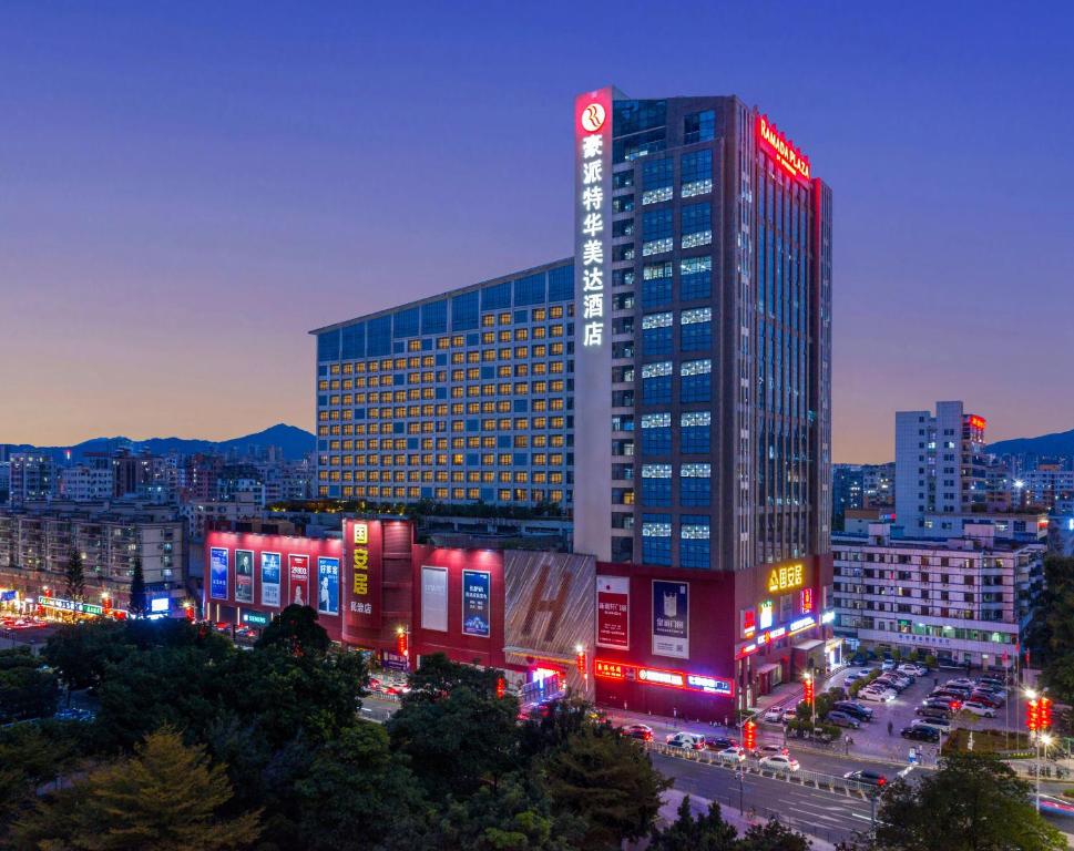 رامادا بلازا شينزين في شنجن: مبنى طويل مع أضواء حمراء في مدينة في الليل