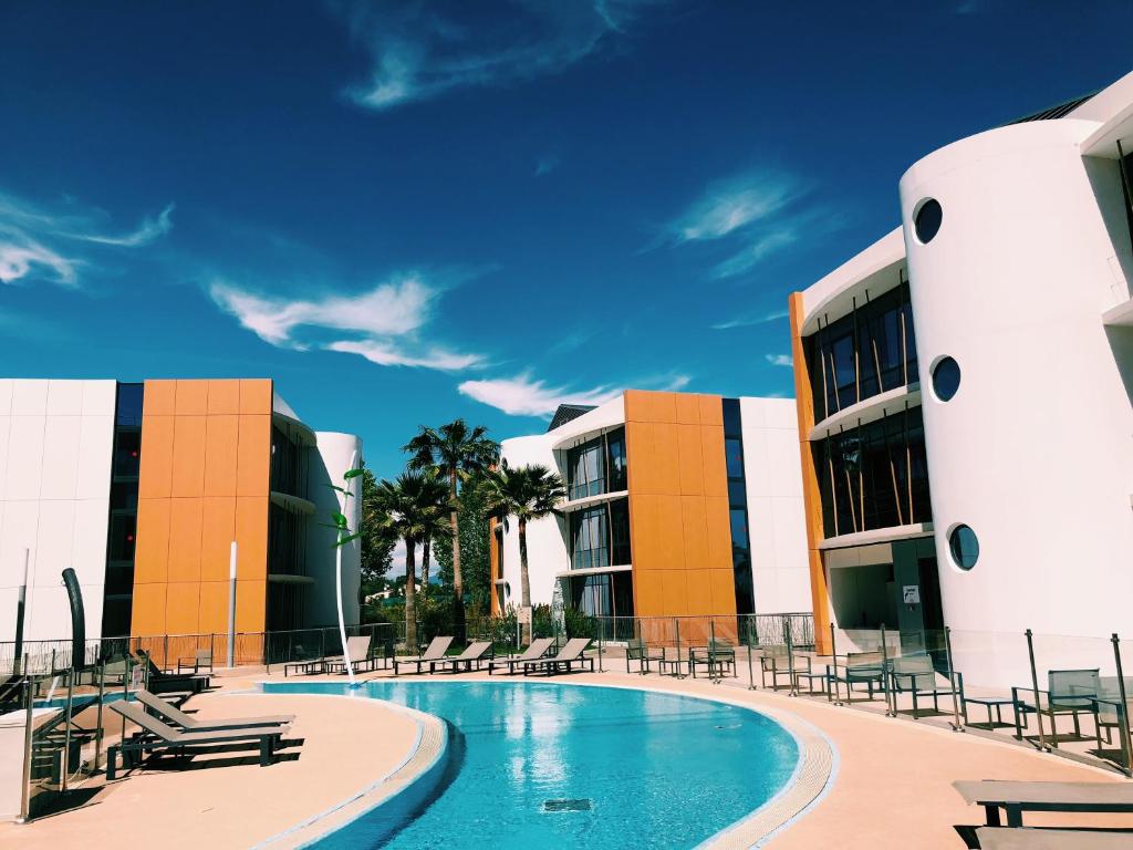 a swimming pool in front of a building at SoBlue Hôtel in Antibes