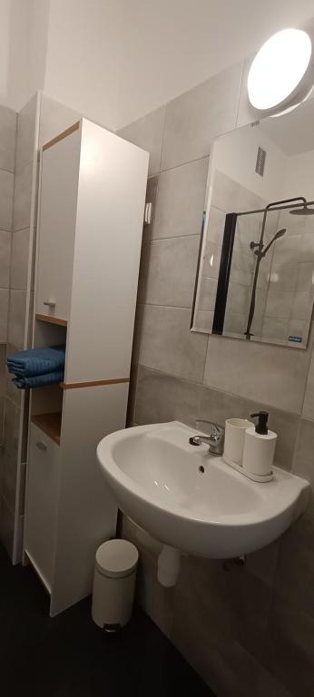 uma casa de banho com um lavatório branco e um espelho. em Helski em Hel