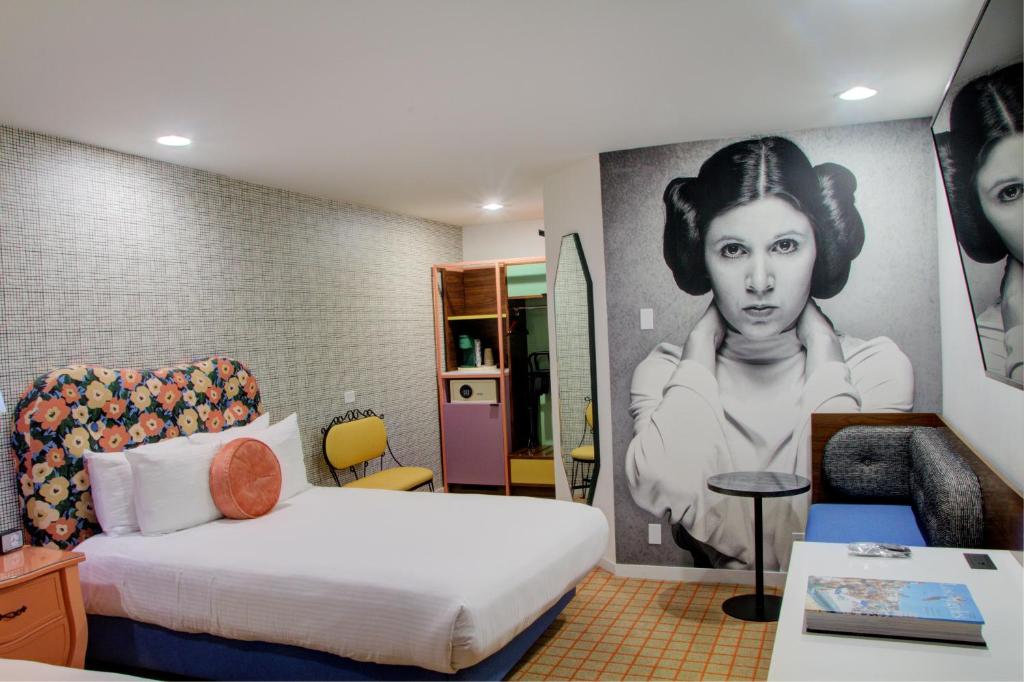 a room with a bed and a painting of a woman at The Adler a Hollywood Hotel in Los Angeles