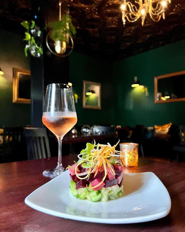 a plate of food and a glass of wine on a table at The Inn at 2nd & C in Eureka
