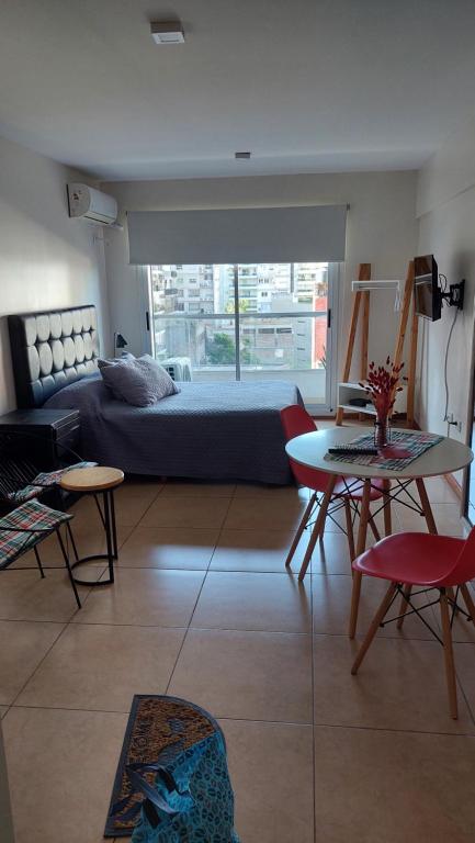 a living room with a bed and a table and chairs at Urquiza 949 in Rosario