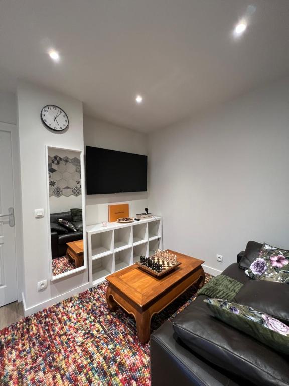 una sala de estar con un sofá y una mesa en Apparte/Hotel de Luxe, en Melun