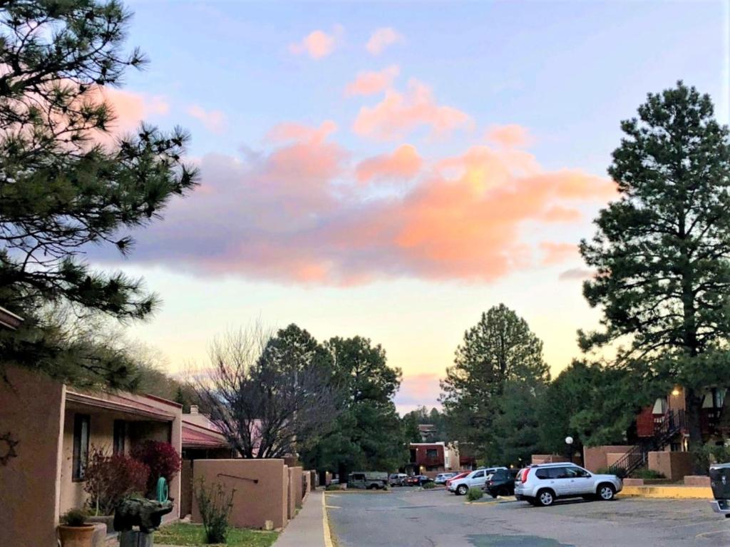 a cloudy sky with cars parked on a street at Pinecliff Village Resort in Ruidoso