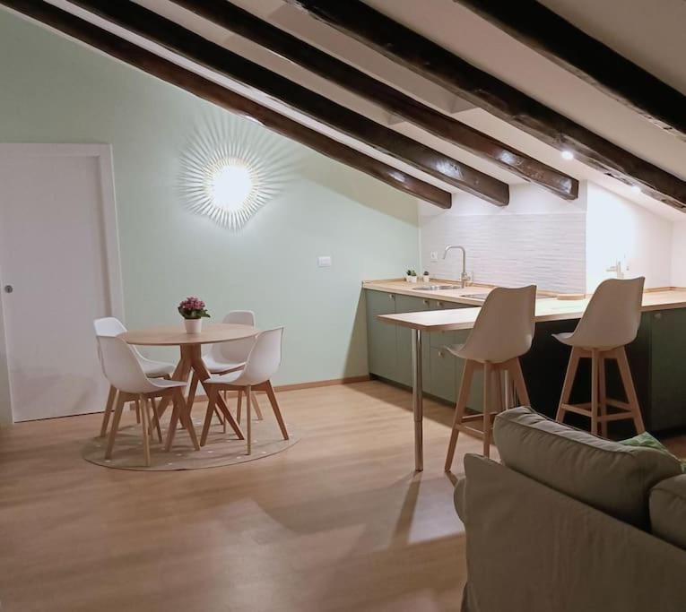 uma sala de estar com mesa e cadeiras e uma cozinha em Loving My Rooms 1 - Deliziosa Mansarda in Centro em Gorizia
