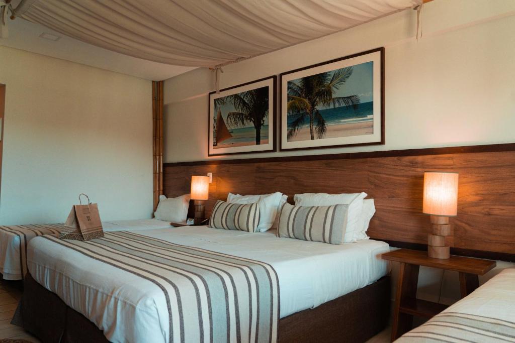 a hotel room with two beds and two lamps at Samoa Beach Resort in Porto De Galinhas