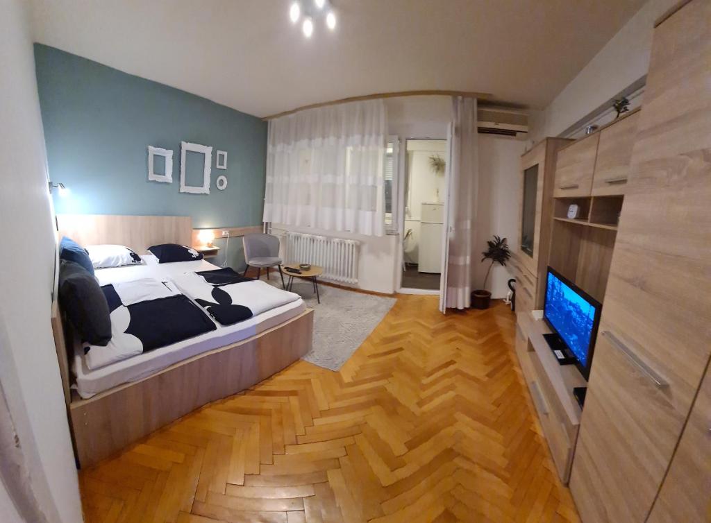 a bedroom with a large bed and a flat screen tv at Kineski zid in Zenica