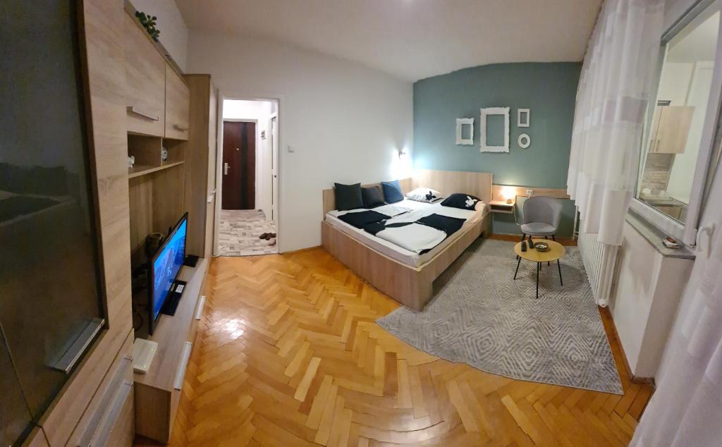 um quarto com uma cama e uma televisão em Kineski zid em Zenica