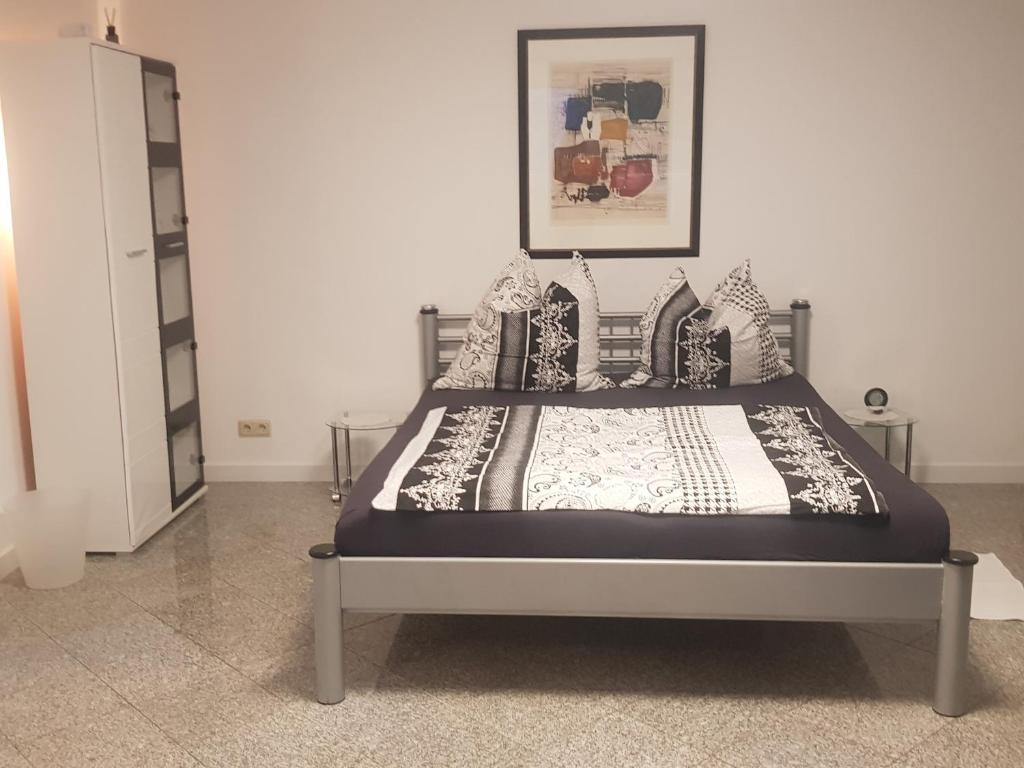 a bed with a black and white comforter in a room at HAUS Madelaine in Neu-Anspach