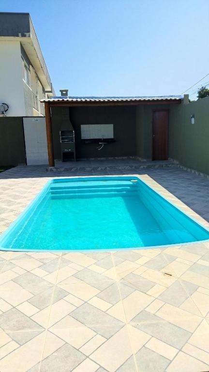 una piscina azul frente a una casa en Apartamento Praia Taperapuan, en Porto Seguro