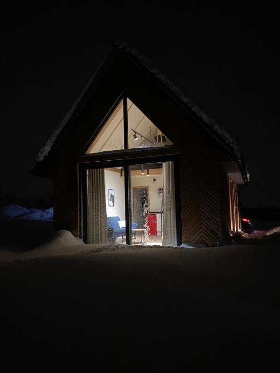 Una ventana de una casa con nieve en el suelo. en Stodoła na polanie, en Poronin