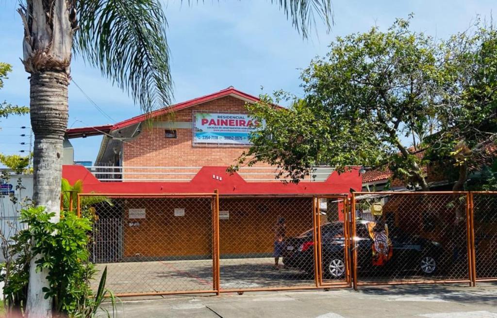 a garage with a car parked in front of a building at Pousada Residencial Paineiras in Guaratuba