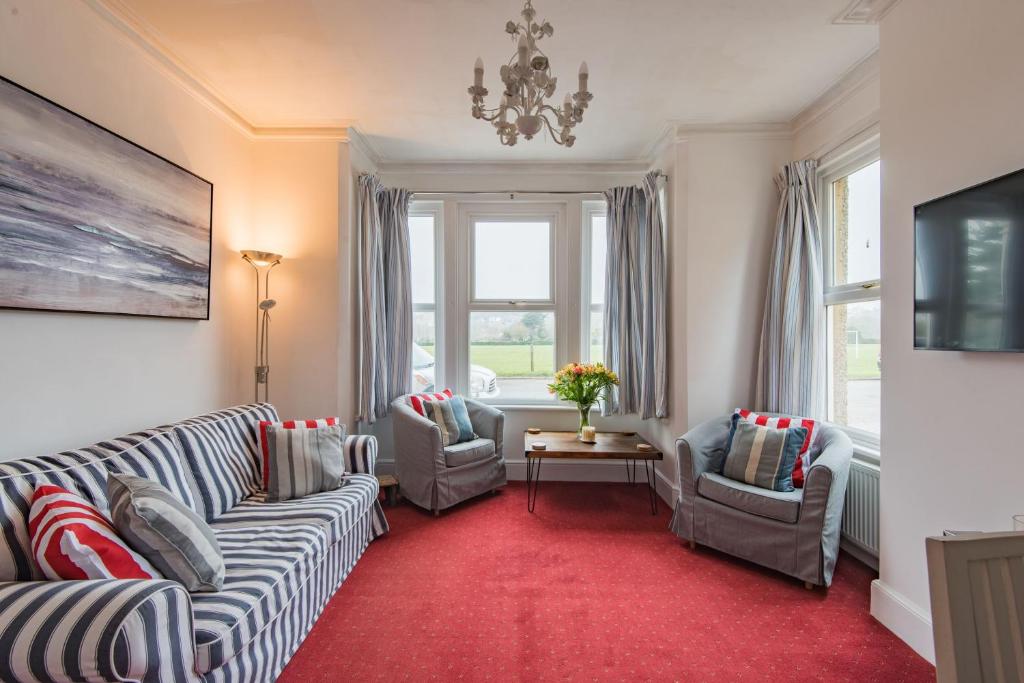 un soggiorno con 2 divani e un tappeto rosso di Southbeach by Bloom Stays a Hythe