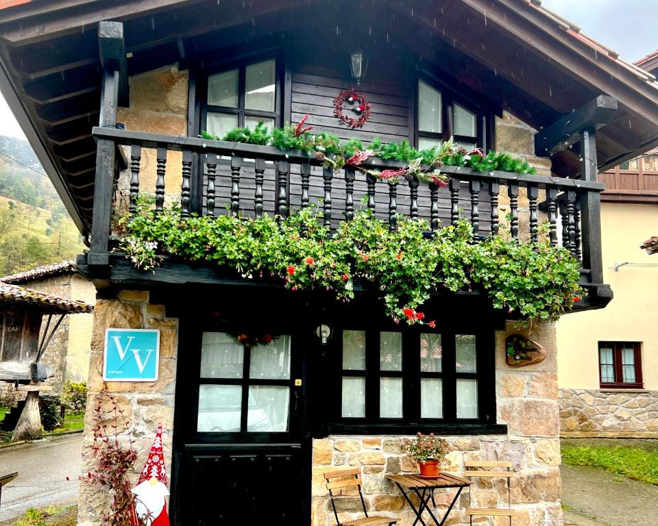 a house with a balcony with flowers on it at La casita de Olivia Espinaredo in La Villa