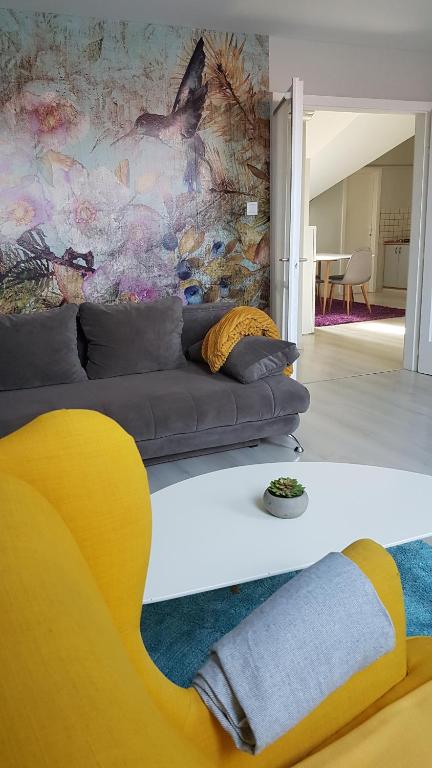 sala de estar con sofá y pintura en Promenad Apartman en Mohács