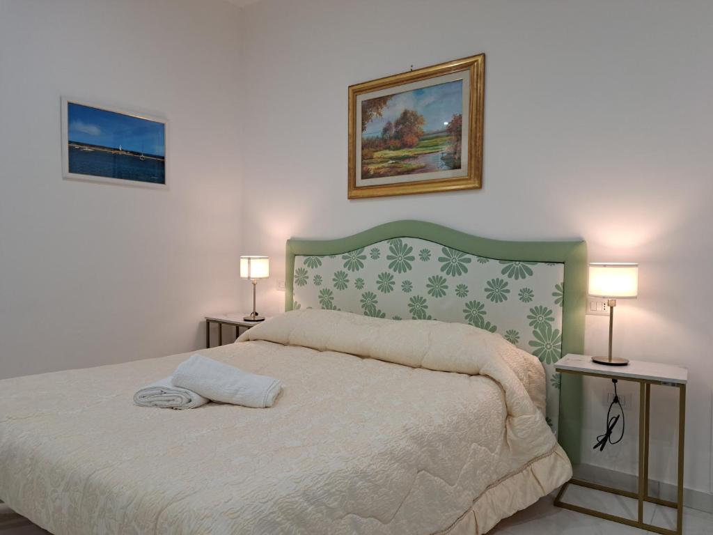 1 dormitorio con 1 cama con 2 lámparas en 2 mesas en Tina’s Room en Santa Maria di Castellabate