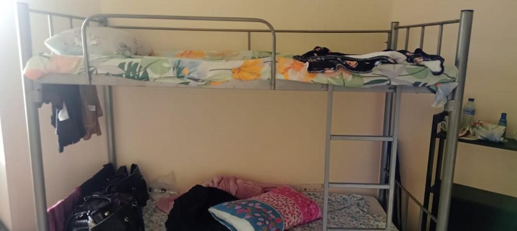 a bedroom with two bunk beds with clothes on them at bed space for weekly with other guests in Dubai