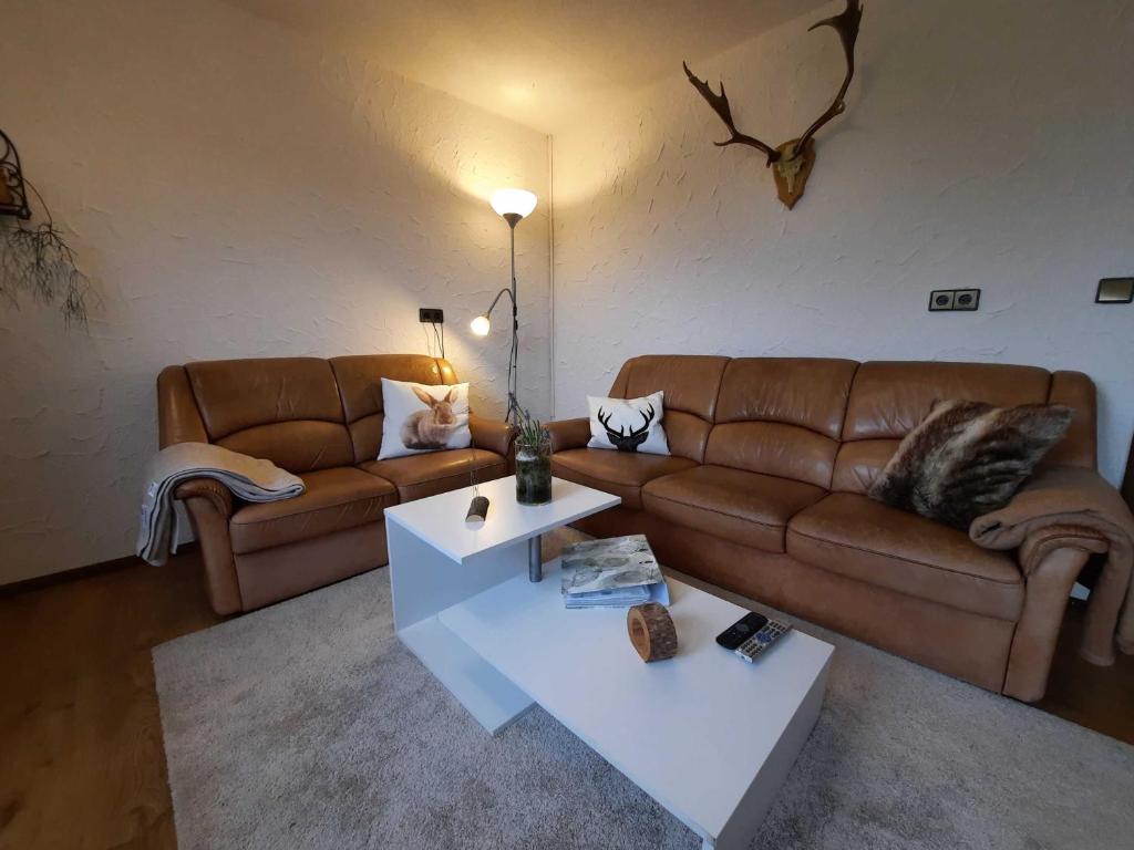 a living room with two couches and a coffee table at Blumenschein-Ferienwohnung Obbe in Kirchzell