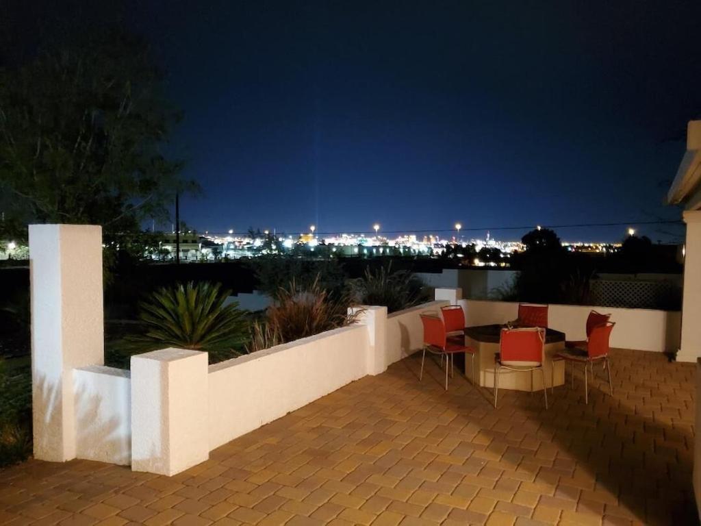 a patio with a table and chairs at night at Stunning Strip and Mountain Views in Las Vegas in Las Vegas