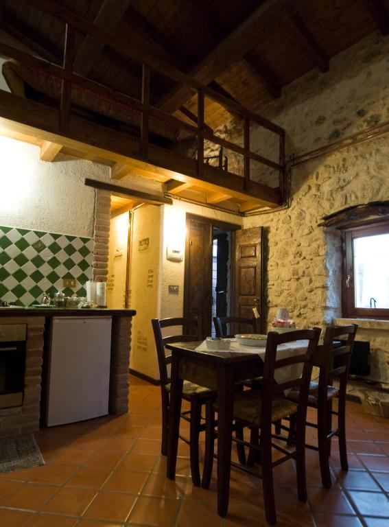 kuchnia i jadalnia ze stołem i krzesłami w obiekcie La Casa Sù Le Dimore Del Borgo w mieście Santo Stefano di Sessanio