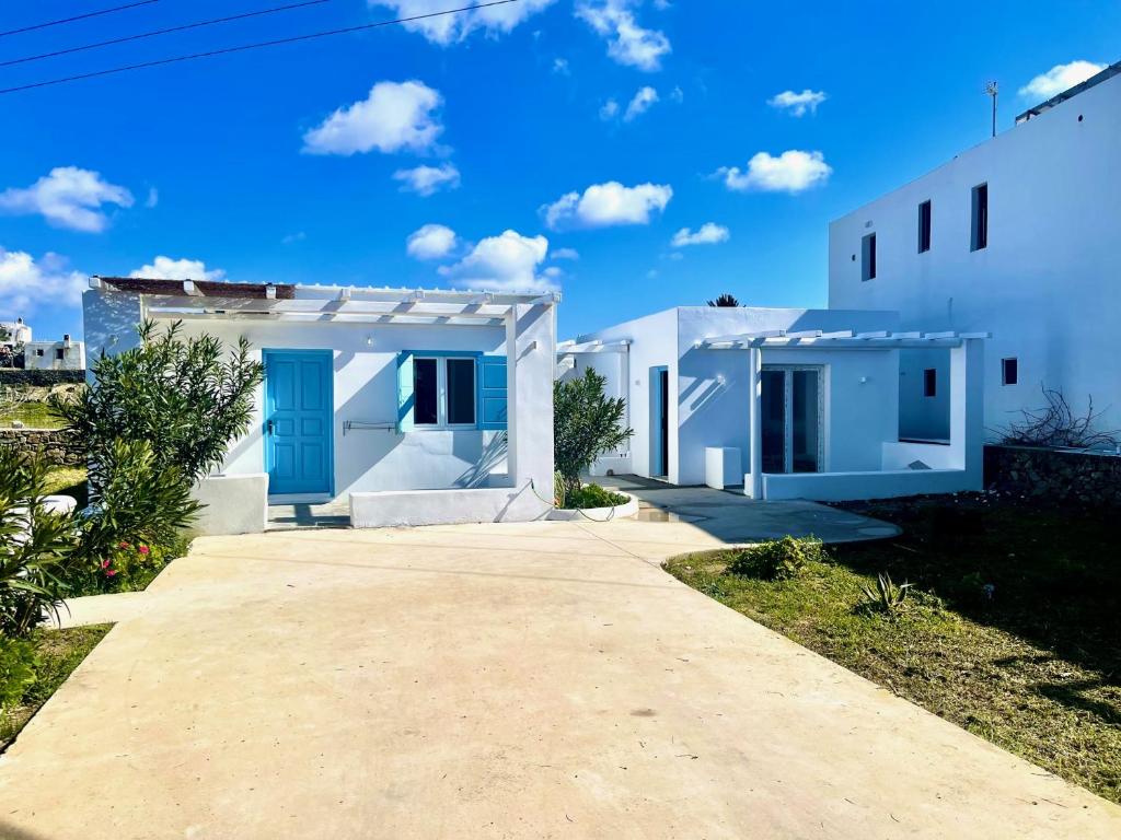 Casa blanca con puertas azules y entrada en La Villa Rooms en Mykonos ciudad