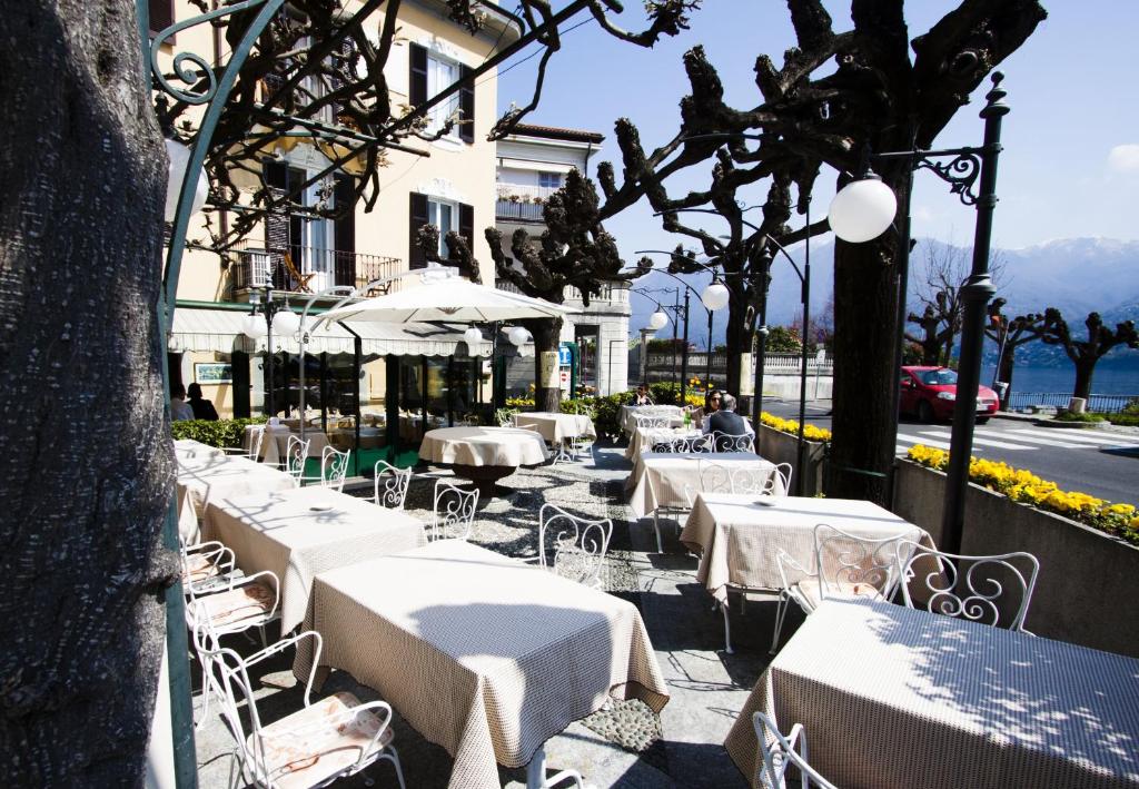 
a dining area with tables and chairs and umbrellas at Hotel Posta in Moltrasio

