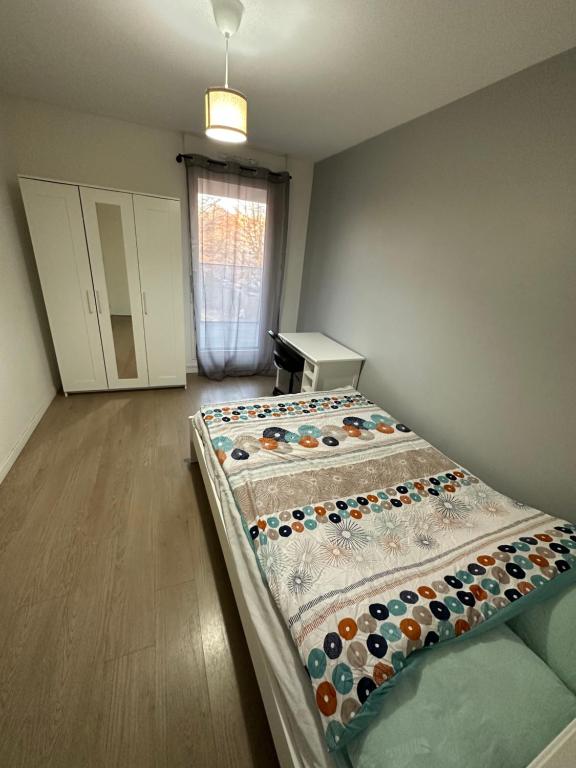 Zimmer mit einem Bett in einem Zimmer in der Unterkunft Logement La courneuve-Aubervilliers RerB in La Courneuve