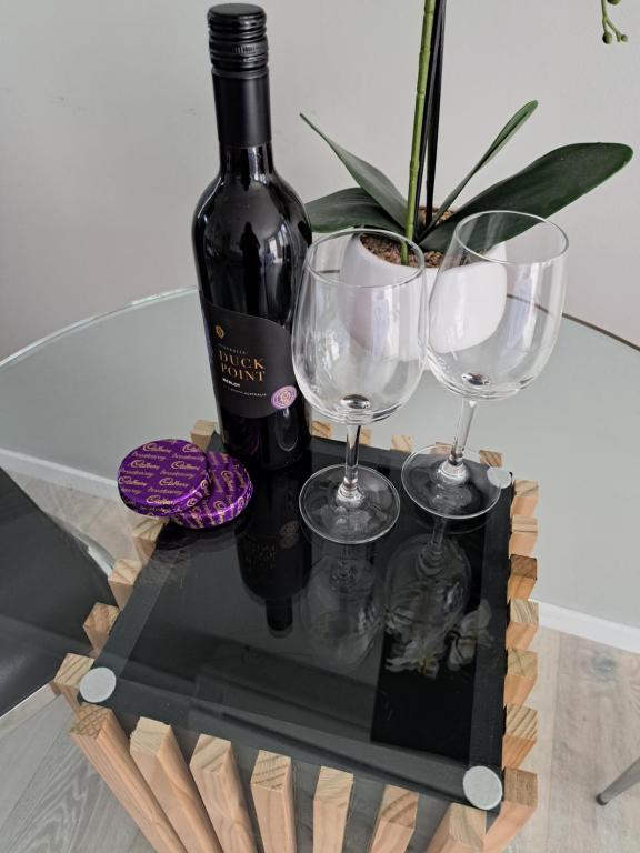 butelkę wina i dwa kieliszki na stole w obiekcie Sunbrae Beach luxury w mieście Mount Maunganui