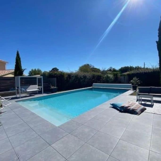 une grande piscine sur une terrasse carrelée avec dans l'établissement Villa de standing proche Airbus et Meet, à Aussonne