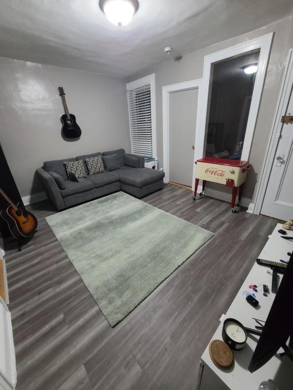 a living room with a couch and a table and a television at comfortable private apartment near Manhattan on train in Woodside