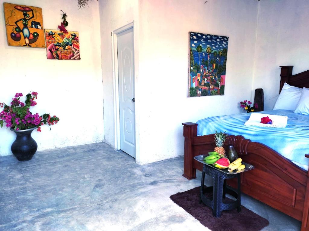 Un dormitorio con una cama y una mesa con fruta. en Hotel i t a, en Las Galeras